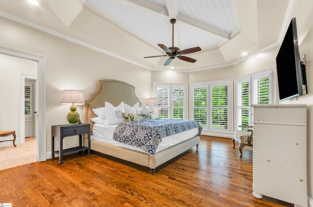bedroom featuring a ceiling fan, beam ceiling, wood finished floors, baseboards, and ornamental molding