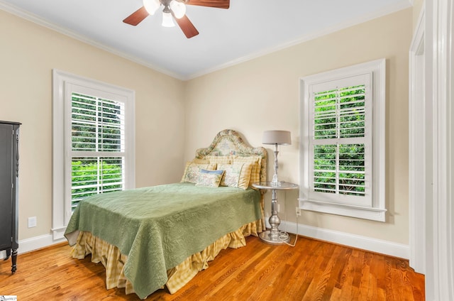 bedroom featuring baseboards, ornamental molding, ceiling fan, and wood finished floors