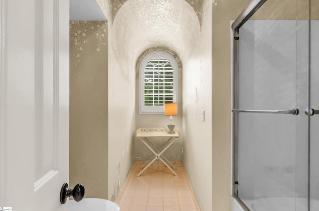 full bath with an enclosed shower and tile patterned floors