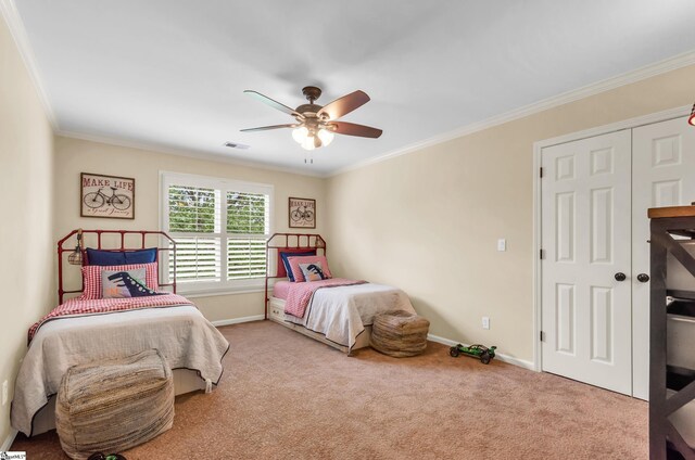 carpeted bedroom featuring baseboards, ornamental molding, a ceiling fan, and visible vents