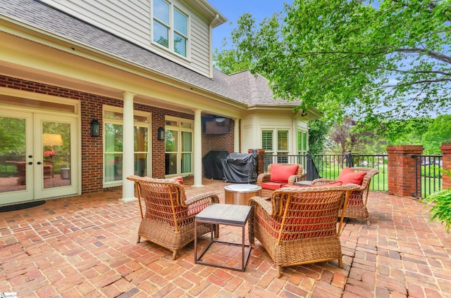 view of patio / terrace featuring area for grilling, fence, outdoor lounge area, and french doors