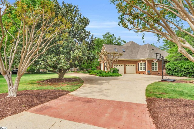 view of front facade with brick siding, decorative driveway, a front lawn, and a garage