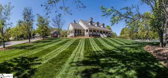 rear view of property with a lawn and fence