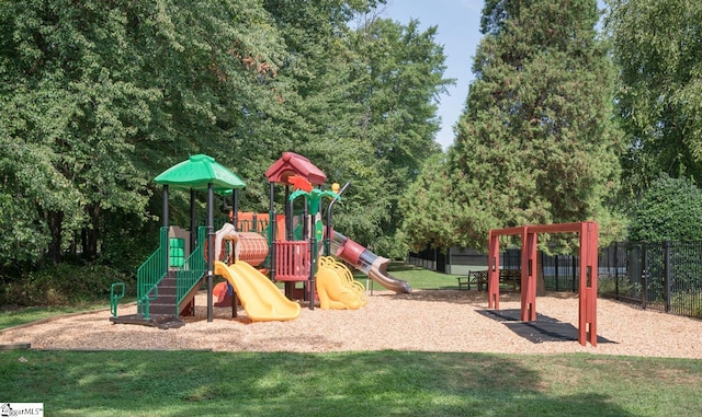community play area featuring fence and a yard