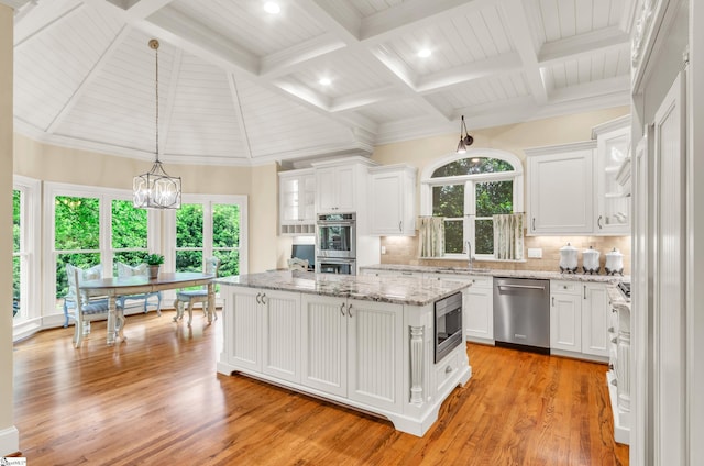 kitchen with a kitchen island, stainless steel appliances, and white cabinetry
