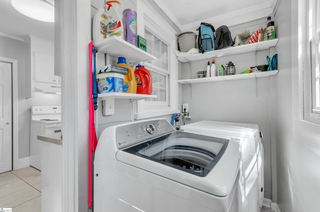 washroom featuring crown molding, light tile patterned floors, laundry area, and washer and clothes dryer