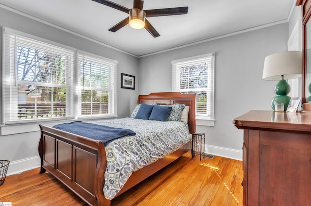 bedroom with crown molding, baseboards, and light wood-type flooring