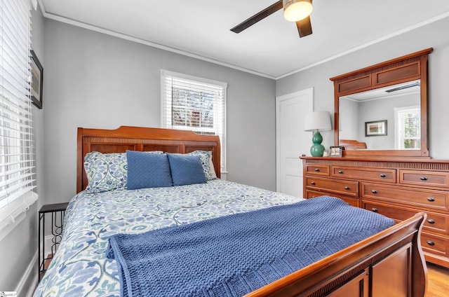 bedroom with crown molding, ceiling fan, baseboards, and light wood finished floors
