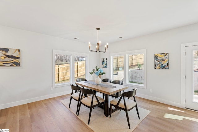 dining room featuring baseboards, a notable chandelier, visible vents, and light wood-style floors