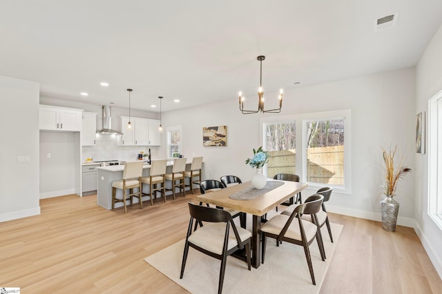 dining space featuring light wood-style floors, an inviting chandelier, and a wealth of natural light