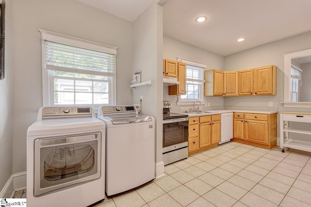 kitchen featuring white dishwasher, stainless steel range with electric cooktop, a sink, light countertops, and separate washer and dryer