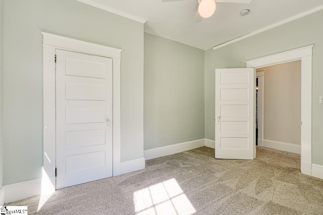 unfurnished bedroom with crown molding, baseboards, and carpet