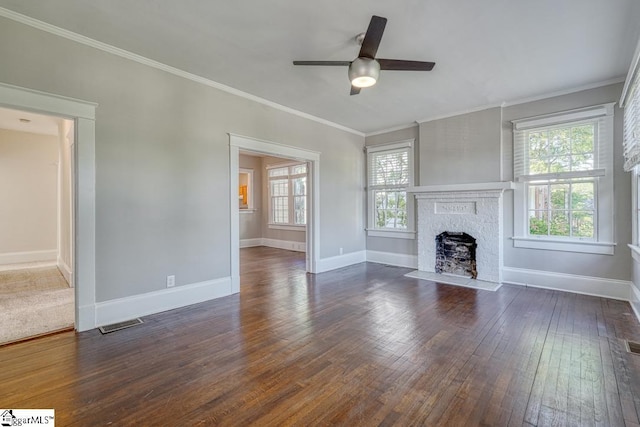 unfurnished living room featuring a brick fireplace, dark wood-style flooring, ceiling fan, and baseboards