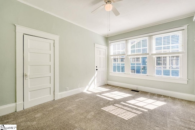 empty room with a healthy amount of sunlight, carpet, a ceiling fan, and visible vents