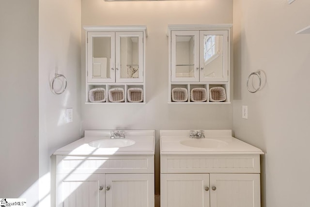 bathroom featuring a sink and two vanities