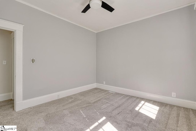 empty room with carpet floors, ceiling fan, ornamental molding, and baseboards