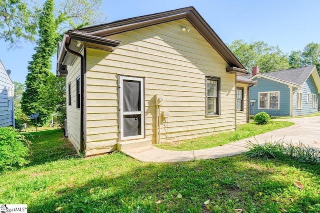 rear view of house featuring a lawn