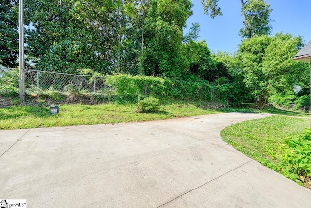 view of home's community featuring fence and driveway