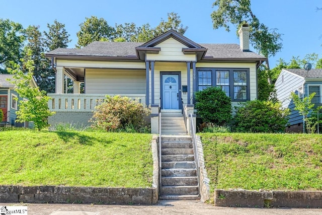 bungalow-style home featuring a front lawn and a chimney