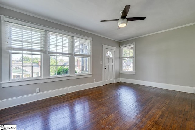 spare room with ceiling fan, dark wood finished floors, baseboards, visible vents, and ornamental molding