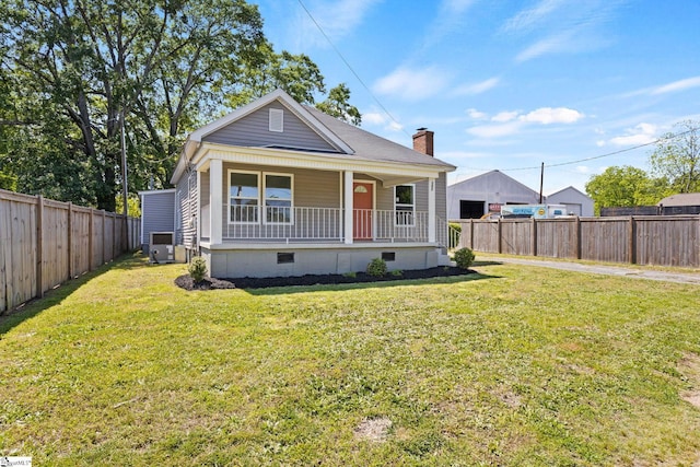 view of front of house with a fenced backyard, covered porch, a front yard, and crawl space