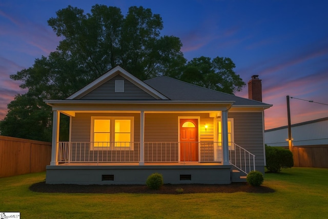 bungalow-style home featuring covered porch, crawl space, and fence