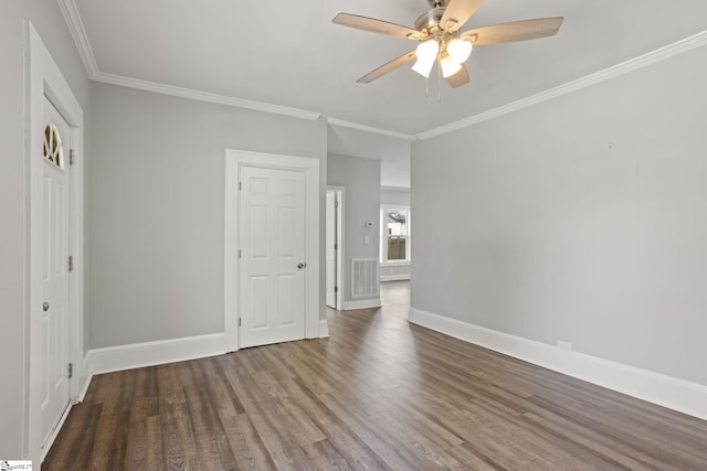 interior space with a ceiling fan, baseboards, wood finished floors, visible vents, and ornamental molding
