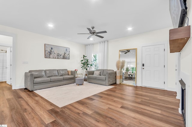 living room with a ceiling fan, recessed lighting, and wood finished floors