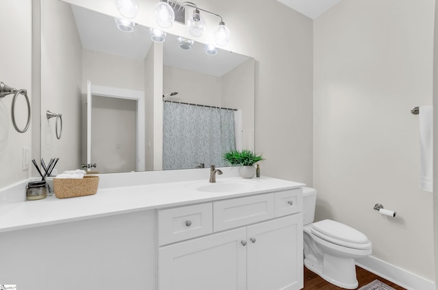 bathroom featuring vanity, wood finished floors, toilet, baseboards, and a shower with shower curtain