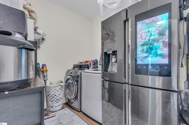 laundry room featuring separate washer and dryer, laundry area, and wood finished floors
