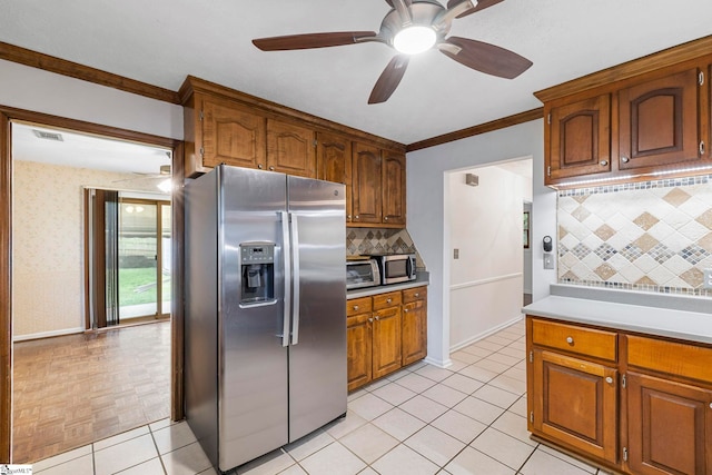 kitchen featuring decorative backsplash, ceiling fan, light countertops, brown cabinets, and appliances with stainless steel finishes