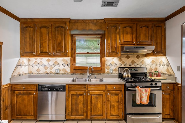 kitchen featuring appliances with stainless steel finishes, a sink, light countertops, under cabinet range hood, and visible vents