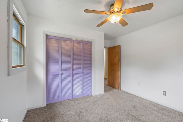 unfurnished bedroom featuring a closet, baseboards, a ceiling fan, and carpet flooring
