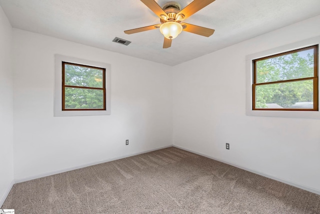 unfurnished room featuring visible vents, carpet, ceiling fan, and baseboards
