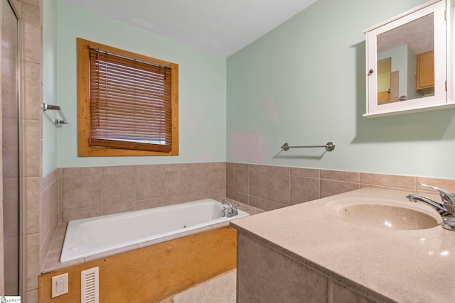 full bath with visible vents, a bath, and vanity