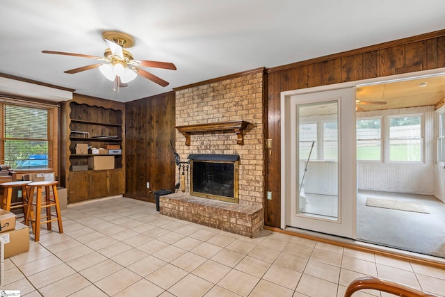 unfurnished living room featuring wooden walls, a ceiling fan, and light tile patterned floors
