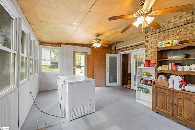 interior space featuring wooden walls, laundry area, and a ceiling fan