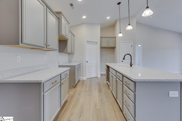 108 Walters Way, Pickens, SC 29671 - kitchen featuring gray cabinets, a sink, an island with sink, light wood-style floors, and vaulted ceiling