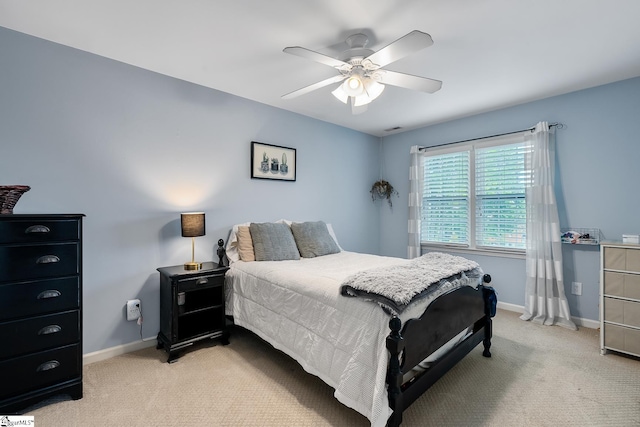 bedroom featuring light colored carpet, baseboards, and ceiling fan
