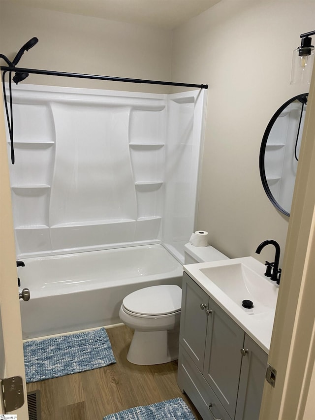 full bath with vanity, toilet, wood finished floors, and tub / shower combination