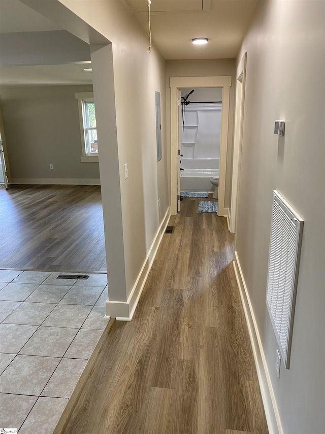 corridor featuring visible vents, attic access, baseboards, and wood finished floors