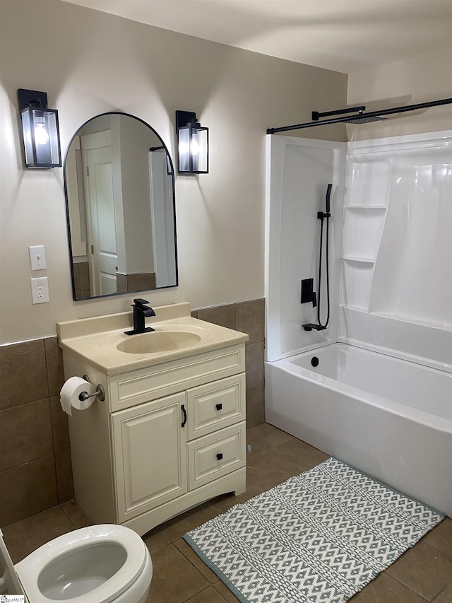 bathroom with tile patterned flooring, vanity, bathing tub / shower combination, and tile walls