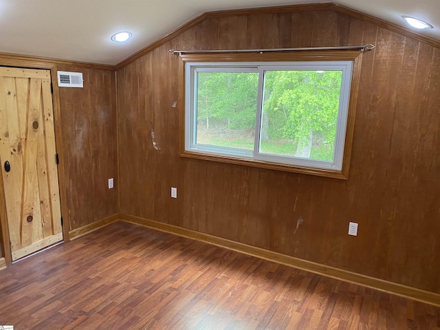 bonus room with wooden walls, visible vents, wood finished floors, and lofted ceiling