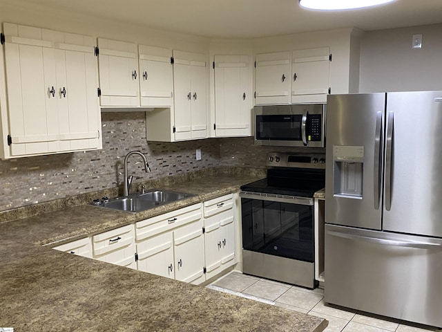 kitchen featuring white cabinets, light tile patterned floors, appliances with stainless steel finishes, and a sink