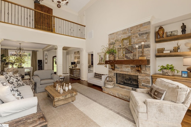 17 Avens Hill Dr, Greer, SC 29651 - living area featuring a stone fireplace, wood finished floors, a chandelier, ornamental molding, and ornate columns