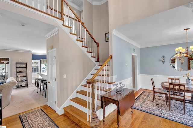 105 Chariot Ln, Simpsonville, SC 29681 - staircase featuring visible vents, crown molding, wainscoting, wood finished floors, and a chandelier