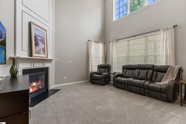 502 Kingsmoor Dr, Simpsonville, SC 29681 - carpeted living area featuring baseboards, a fireplace with flush hearth, and a towering ceiling