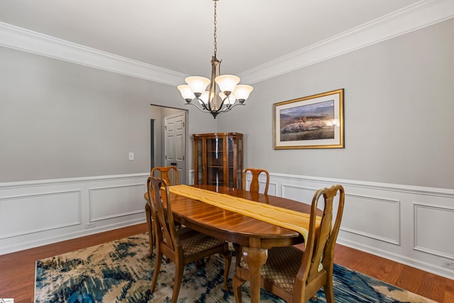 502 Kingsmoor Dr, Simpsonville, SC 29681 - dining space featuring crown molding, a decorative wall, a chandelier, a wainscoted wall, and wood finished floors