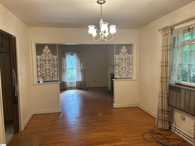 402 Chestnut St, Clinton, SC 29325 - unfurnished dining area featuring baseboards, a chandelier, plenty of natural light, and wood finished floors