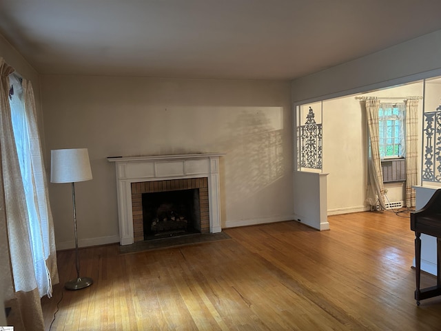 402 Chestnut St, Clinton, SC 29325 - unfurnished living room with wood-type flooring, baseboards, and a brick fireplace